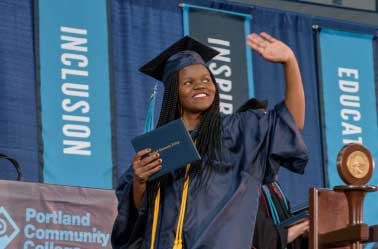 female graduate waving