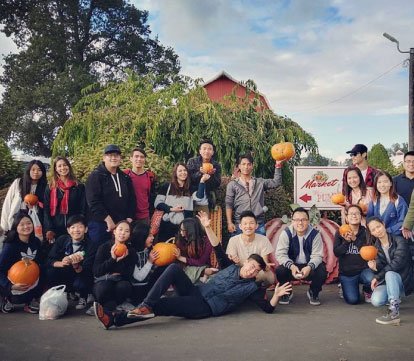 smiling students with carved pumpkins